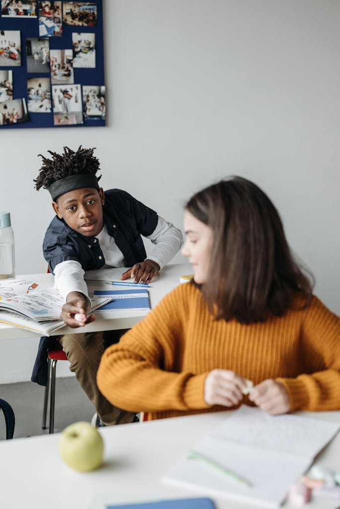 Students interact in a classroom setting, exchanging supplies and ideas.